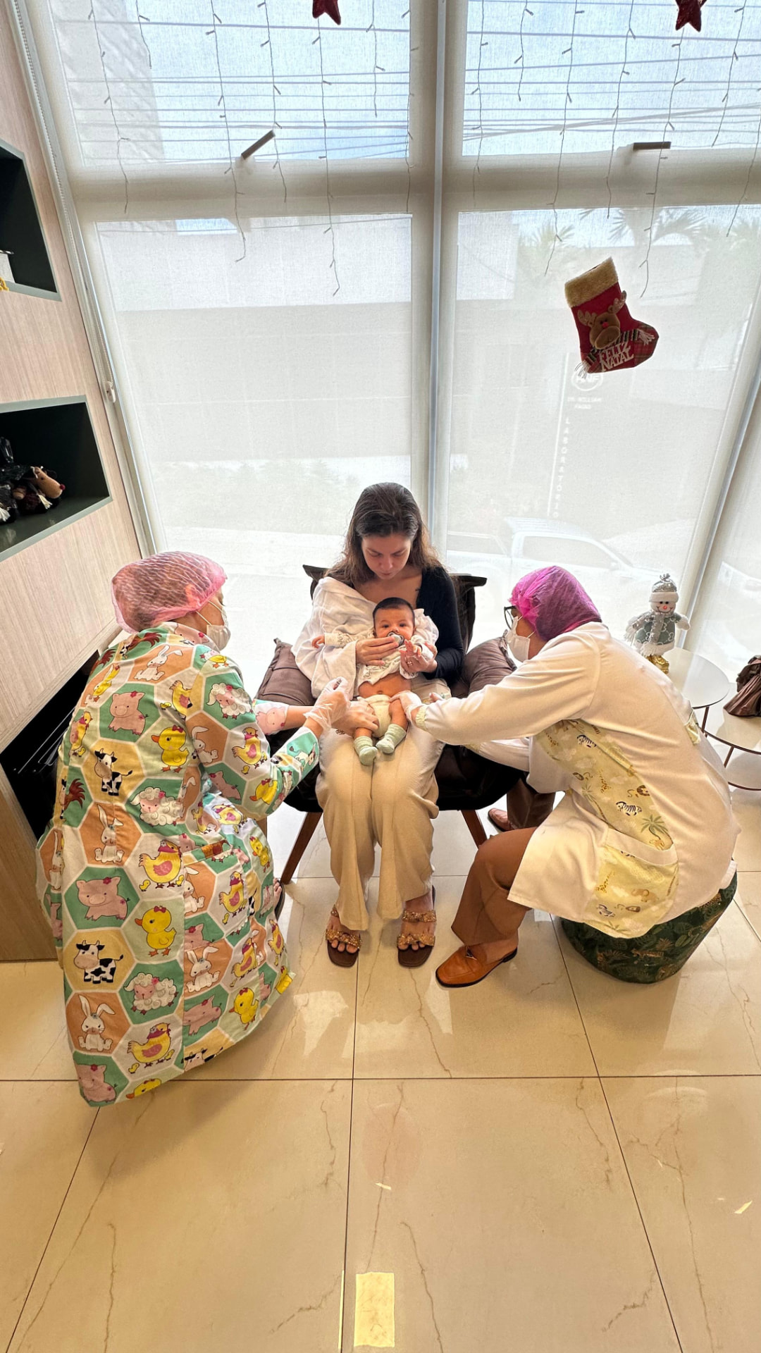 Equipe da Proteja vacinando bebê no colo da mãe em Catalão